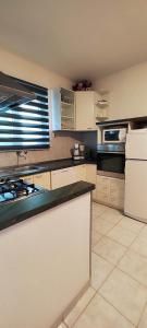 a kitchen with white cabinets and a white refrigerator at Apartments Ita - Postira in Postira