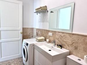 Un baño con lavadora y lavabo. en Pirata Bungalow sea front, en Estepona 14 fotos más