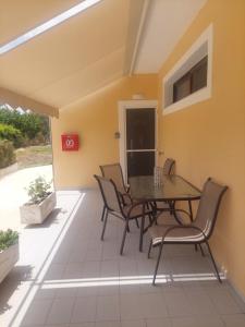 a room with a table and chairs on a patio at Sea Side Studios in Tsilivi