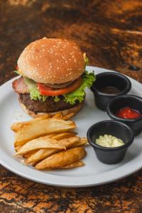 a plate with a hamburger and french fries and ketchup at Hotel Michanti in El Zonte