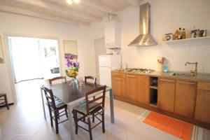 a kitchen with a table with chairs and a refrigerator at Villa Vento Largo, Casa Irene in Ventimiglia +17 photos