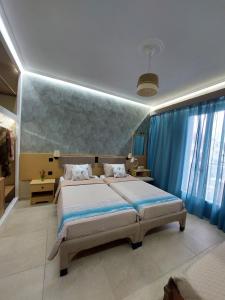 una camera da letto con un grande letto con tende blu di Dionysos Studios a Laganas