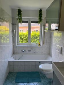 a bathroom with a tub and a toilet and a window at Design-Terrasse-7 Personen-Netflix-Garage-Seenah in Radolfzell am Bodensee +56 photos
