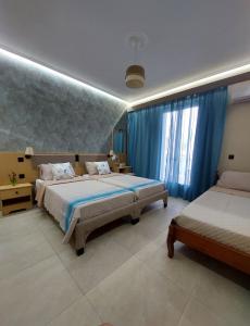 una camera con due letti e tende blu di Dionysos Studios a Laganas