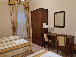 a hotel room with two beds and a desk and a mirror at casapaceebene in San Giovanni Rotondo