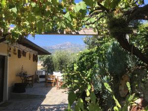 a patio with a table and chairs and a mountain at Villa Vento Largo, Casa Irene in Ventimiglia