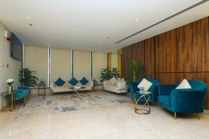 um átrio com cadeiras e mesas azuis num edifício em Noor Amwaj Hotel & Apartment em Manama