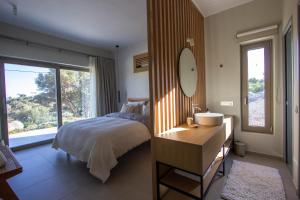 Un dormitorio con una cama, un lavabo y un espejo. en Villa Ninemia, en Agia Galini 53 fotos más