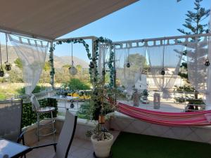 a balcony with a hammock and a table and chairs at Delphitea Philoxenia in Itea