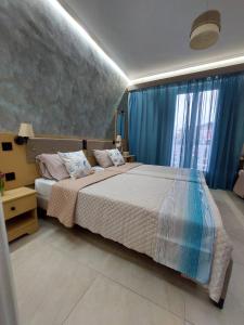 una camera da letto con un grande letto con tende blu di Dionysos Studios a Laganas