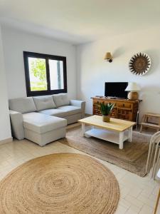 uma sala de estar com um sofá e uma mesa em Minorque maison 4 chambres - licence touristique em Son Bou