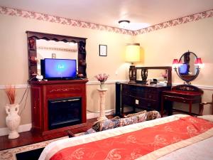 sala de estar con TV y sofá en Apple & Cherry Suite-heart of oldtown, en Niagara on the Lake