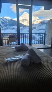 a bedroom with a bed with a view of snow covered mountains at Best view Kazbegi in Kazbegi