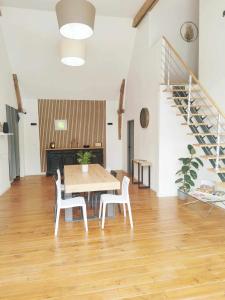 une salle à manger avec une table, des chaises et un escalier dans l'établissement Le domaine du Quercy, à Padirac