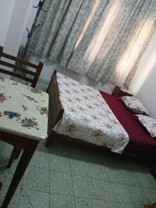 una camera con un letto, un tavolo e una finestra di Hotel de la plage a Bizerte