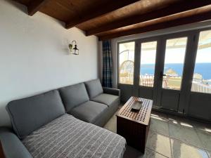 un salon avec un canapé et une table dans l'établissement Sunset view apartment, à Oia