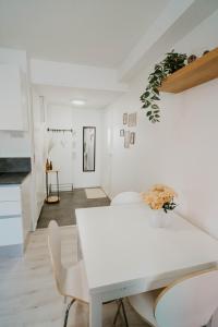 un comedor blanco con una mesa y sillas blancas en ~ A modern flat at a calm ground floor ~ en Espoo