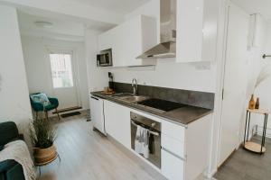 cocina blanca con fregadero y fogones en ~ A modern flat at a calm ground floor ~ en Espoo