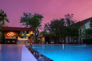 a swimming pool at night with a purple sky at Sukhothai Treasure Resort & Spa- SHA Plus Certified in Sukhothai