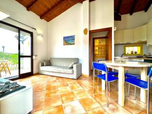 a living room with a table and chairs and a couch at Casetta Al Mare in Àrbatax