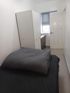 een bed in een kamer met een witte muur bij Budgeted Residence near Coventry Building Society (CBS) Arena with Parking in Exhall