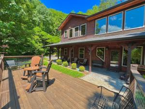 une maison dotée d'une terrasse en bois avec une table et des chaises dans l'établissement South Side Serenity, à Sevierville