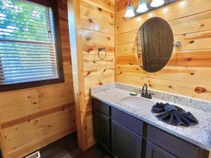 La salle de bains est pourvue d'un lavabo et d'un miroir. dans l'établissement South Side Serenity, à Sevierville