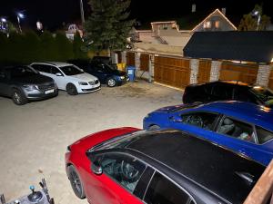 eine Gruppe von Autos, die auf einem Parkplatz geparkt sind in der Unterkunft Penzión Vila Petra Bed&Breakfast in Veľký Slavkov