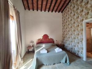 a bedroom with a bed with a red headboard at Agriturismo Podere Campaini in Volterra