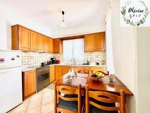 a kitchen with wooden cabinets and a wooden table at Olivóne apt, by A & F in Igoumenitsa