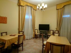a living room with two tables and a television at casapaceebene in San Giovanni Rotondo