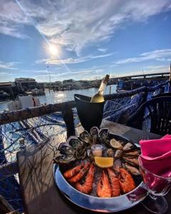 a plate of seafood on a table with a bottle of wine at La Villa Marcel in Le Barcarès +5 photos