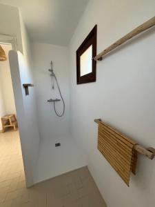 uma casa de banho com um chuveiro numa parede branca em Minorque maison 4 chambres - licence touristique em Son Bou