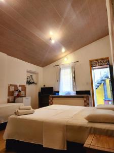 a bedroom with two beds and a window at Pousada Solar Azul in Lençóis