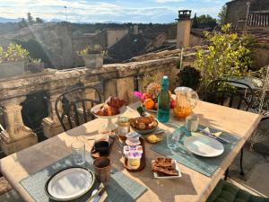 una mesa con comida y bebida en el balcón en La vie de chateau, en Grignan