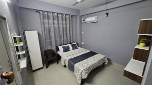 um pequeno quarto com uma cama e uma janela em THE STAY CORNER em Guwahati