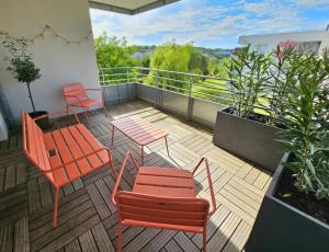 balcone con sedie arancioni, tavoli e piante di Superbe Apt 2 ch, terrasse, WIFI, parking gratuit a Tolosa