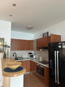 - une cuisine avec des placards en bois et un réfrigérateur noir dans l'établissement Apartman Bebic, à Klek
