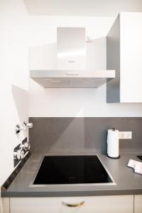 a kitchen with a sink and a stove at C4S -COME4STAY- Stilvoll eingerichtetes Apartment für bis zu 8 Personen - Hochwertige Betten I voll ausgestattete Küche I Balkon I Badezimmer I WLAN I Smart TV in Töging am Inn