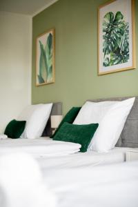 a bedroom with two beds with green and white pillows at C4S -COME4STAY- Stilvoll eingerichtetes Apartment für bis zu 8 Personen - Hochwertige Betten I voll ausgestattete Küche I Balkon I Badezimmer I WLAN I Smart TV in Töging am Inn
