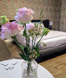 un jarrón lleno de flores rosas en una mesa en Casetta Morris, en Valdobbiadene