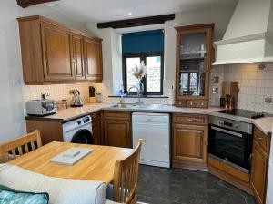 a kitchen with wooden cabinets and a wooden table at Three - Yard 12 in Kendal