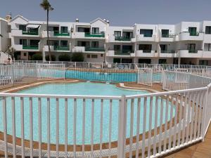 a swimming pool in front of a building at App Tahiche, Encanto Canario in Costa Teguise