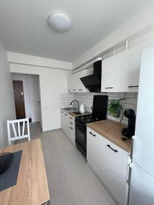 a kitchen with white cabinets and a stove top oven at Radvilų apartamentai in Radviliškis