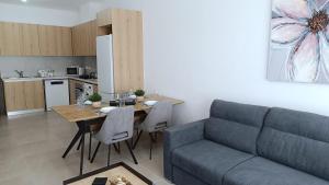 a living room with a couch and a table and a kitchen at Larvella Estia Luxury Suites in Larnaca