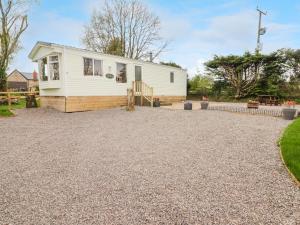 a house with a gravel driveway in front of it at Grandads Shack in Pontypool