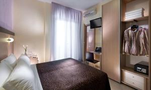 a hotel room with a bed and a television at Hotel Rubens in Rimini