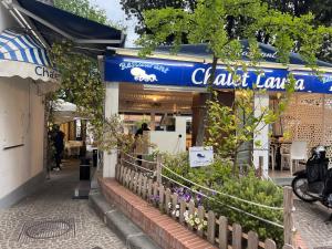 Una tienda con un cartel azul y flores delante. en Ammos Suite Sorrento Coast, en Castellammare di Stabia