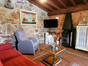 a living room with a couch and a fireplace at Casa Rústica Piscina, Apartadiño in Pobra do Caramiñal