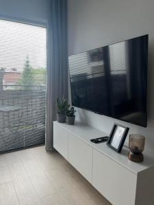 ワンツトにあるApartament 6の白いキャビネット(大型テレビ付)が備わるリビングルーム